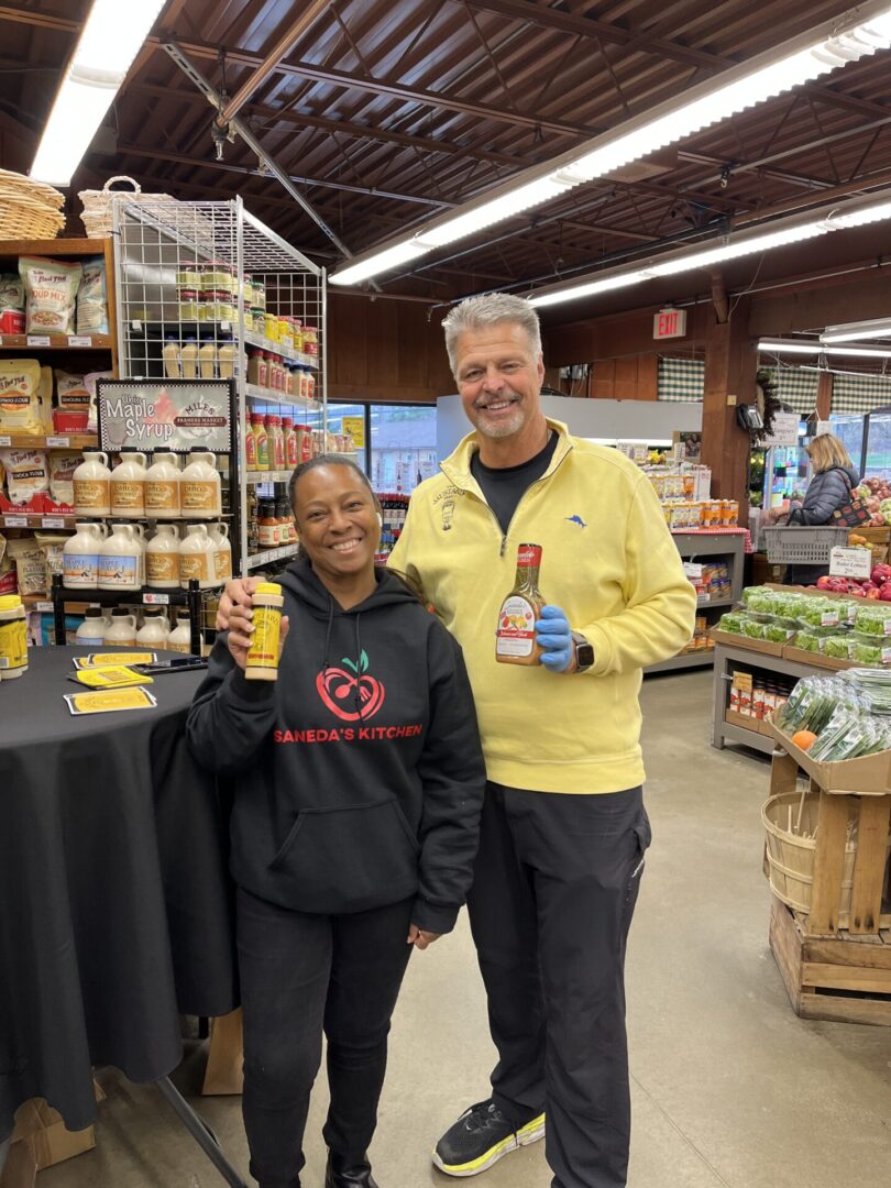 A man and woman holding beer bottles in a store.