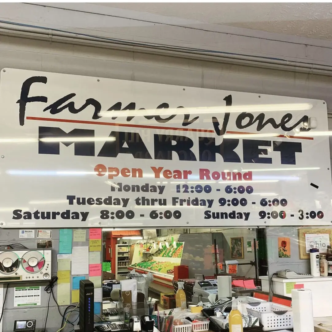 A sign in front of a store that says " farmer jones market open year round ".