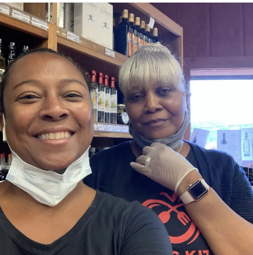 Two women in a wine shop wearing masks