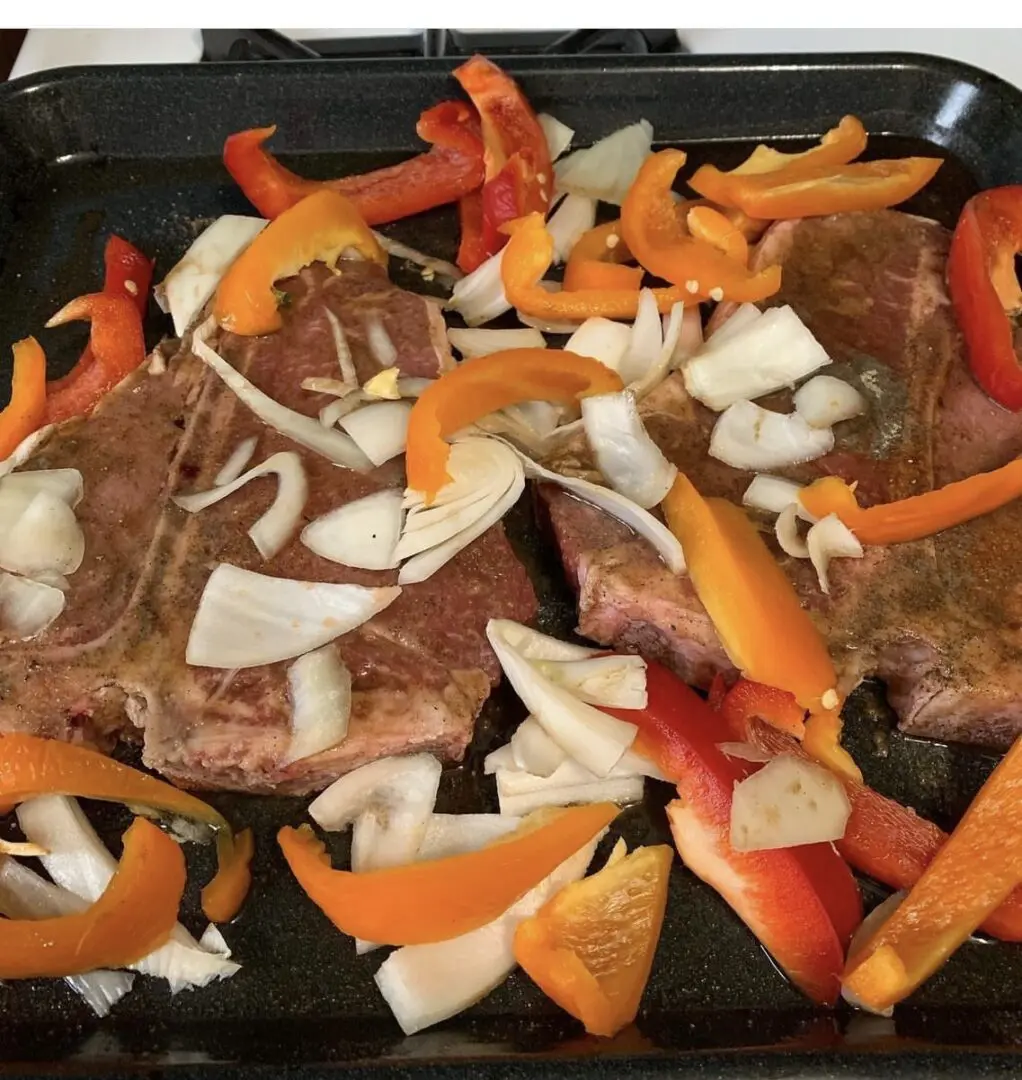 A pan with meat and vegetables on it.