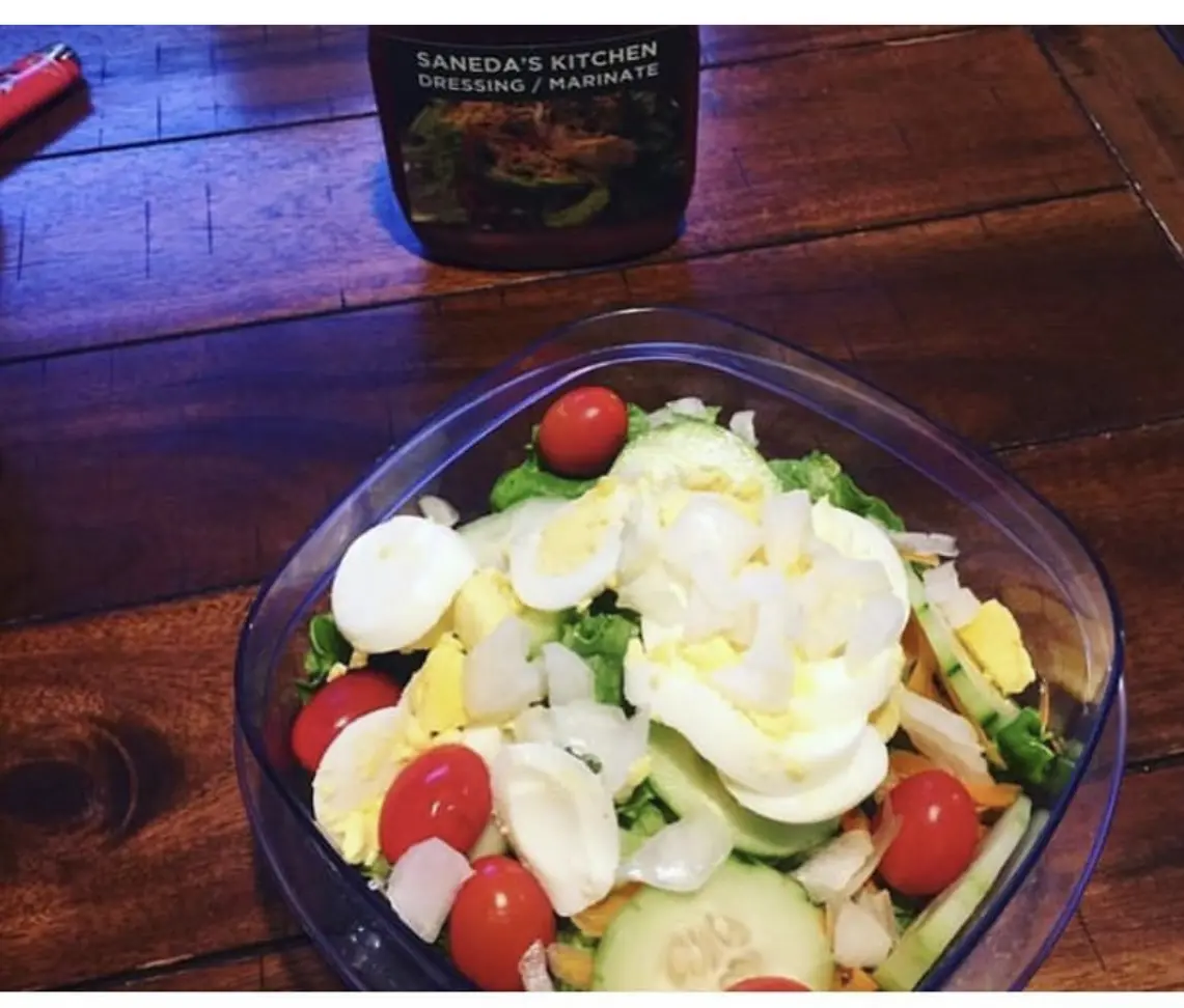 A bowl of salad with tomatoes, eggs and lettuce.